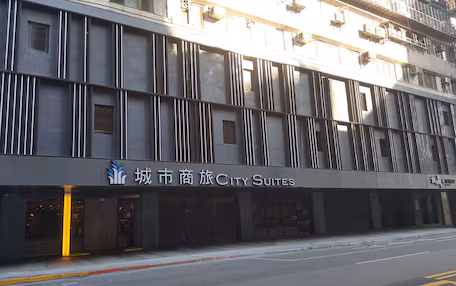 A modern building with a sign for "City Suites".